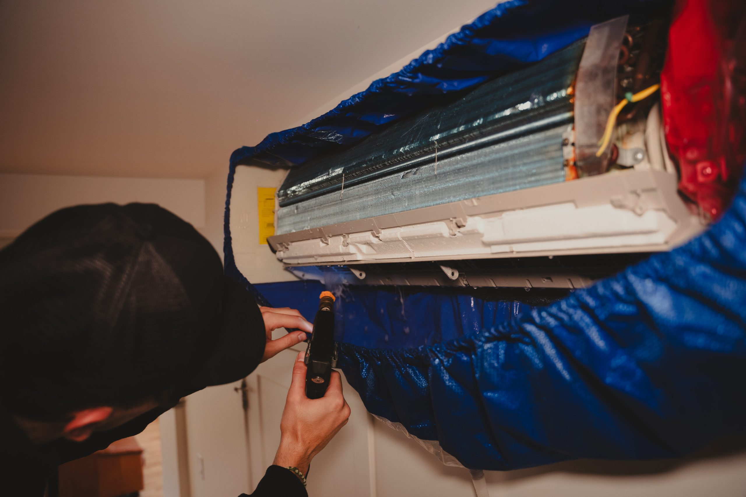 Technicien Nettoyage Exl-Or procédant à l'entretien d'un climatiseur mural / thermopompe en complément du nettoyage de fournaise